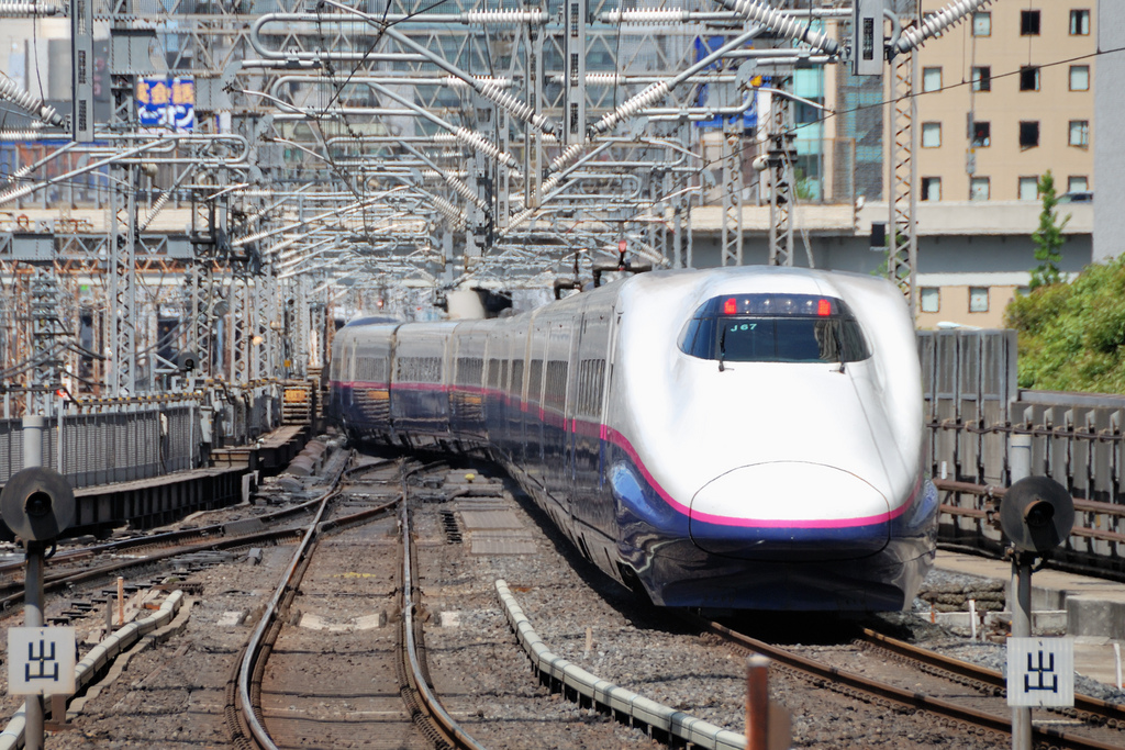 Ein Tohoku-Shinkansen der E2-Serie beim Verlassen des Bahnhofs Tokio.