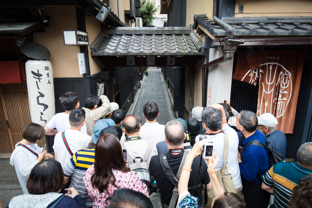 Touristen und Fotografen versuchen, eine Geiko zu fotografieren.