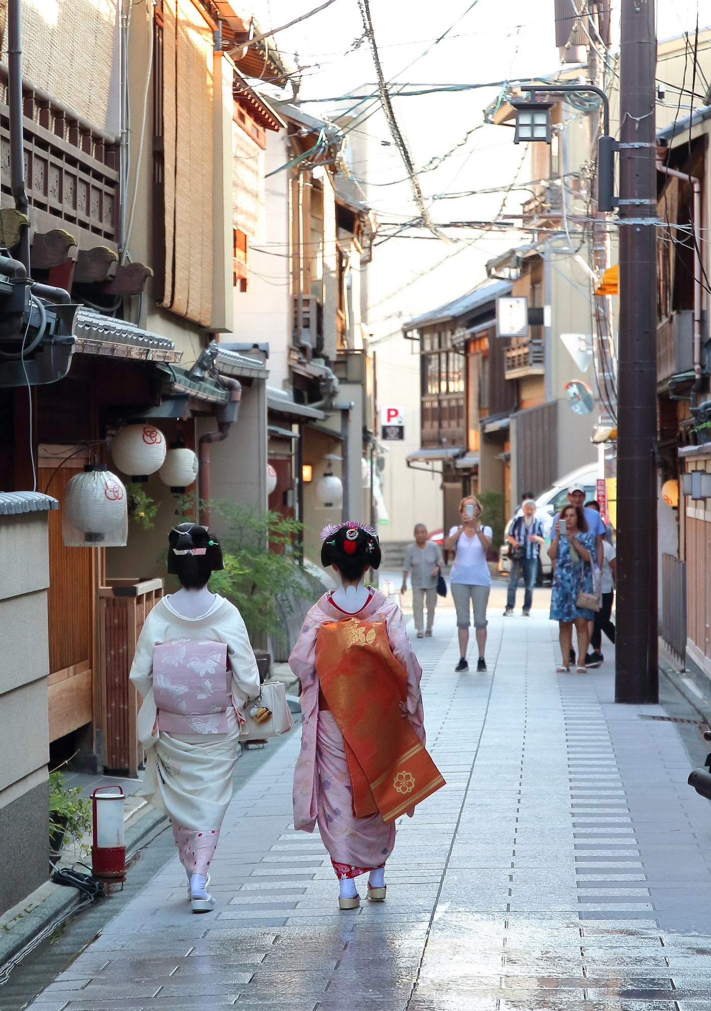 Touristen erblicken eine Geiko und eine Maiko in Kyoto.