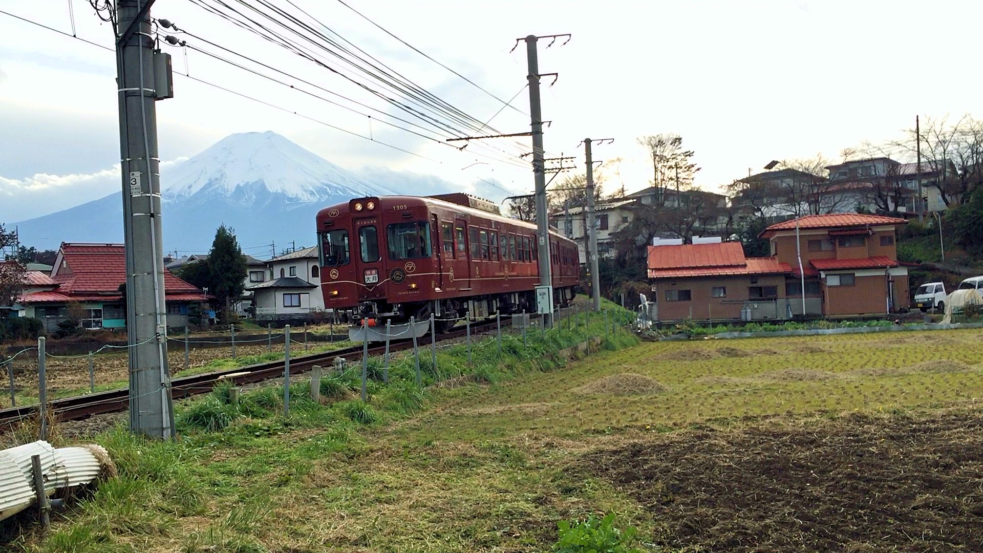 Ein Zug von Fujikyu Railway mit dem Fuji im Hintergrund.