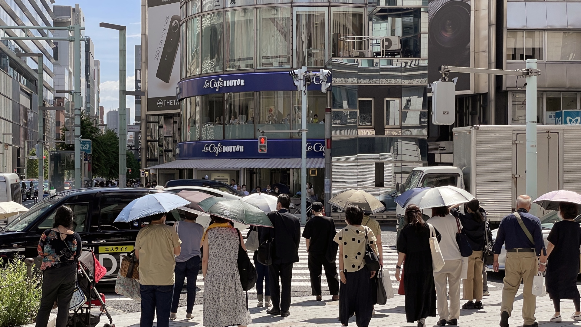 Mit Sonnenschirmen gegen die Hitze. Tokio am 24. Juni 2022.