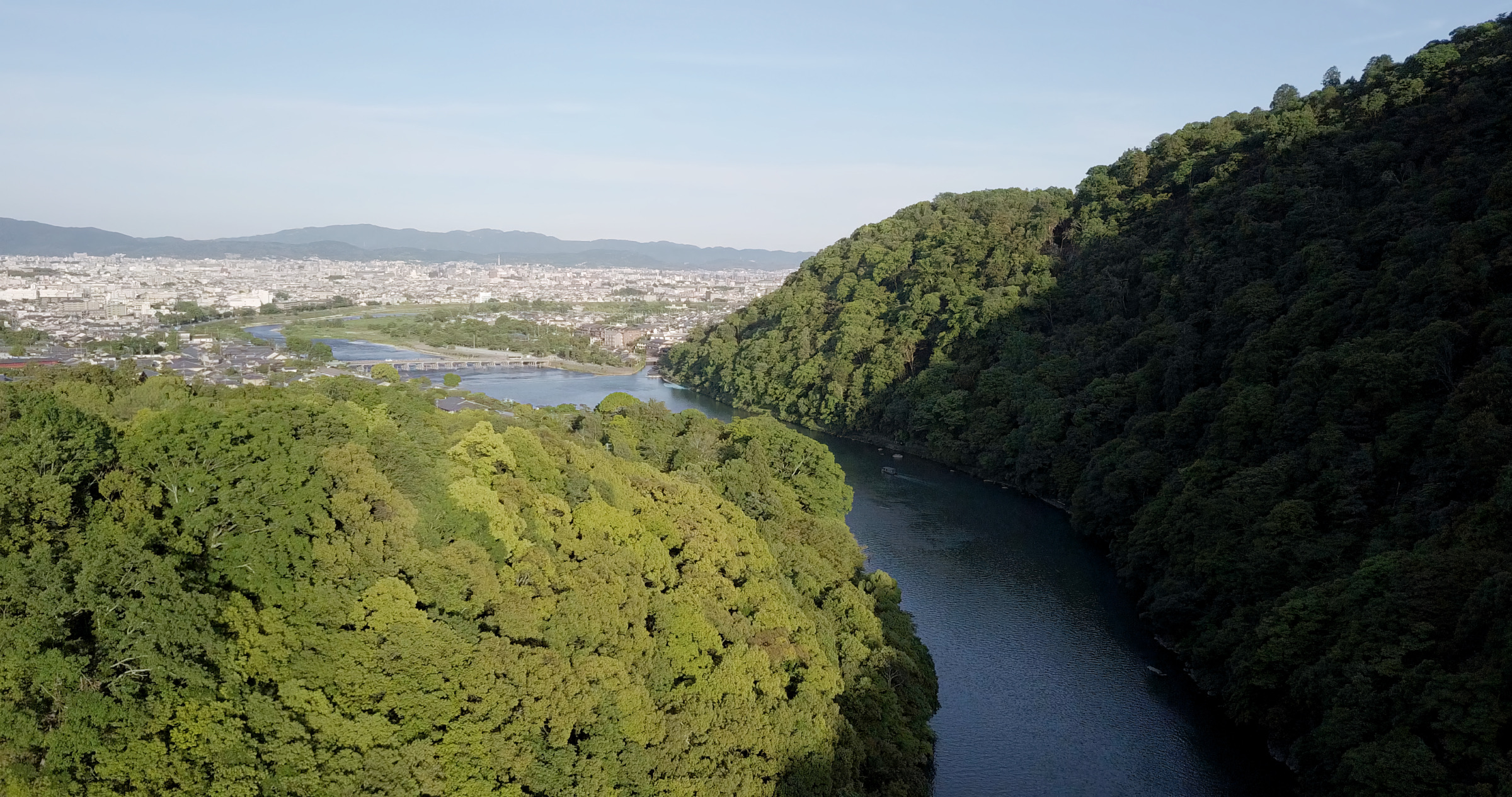 Arashiyama, die Brücke Togetsukyō und die Stadt Kyoto im Hintergrund.