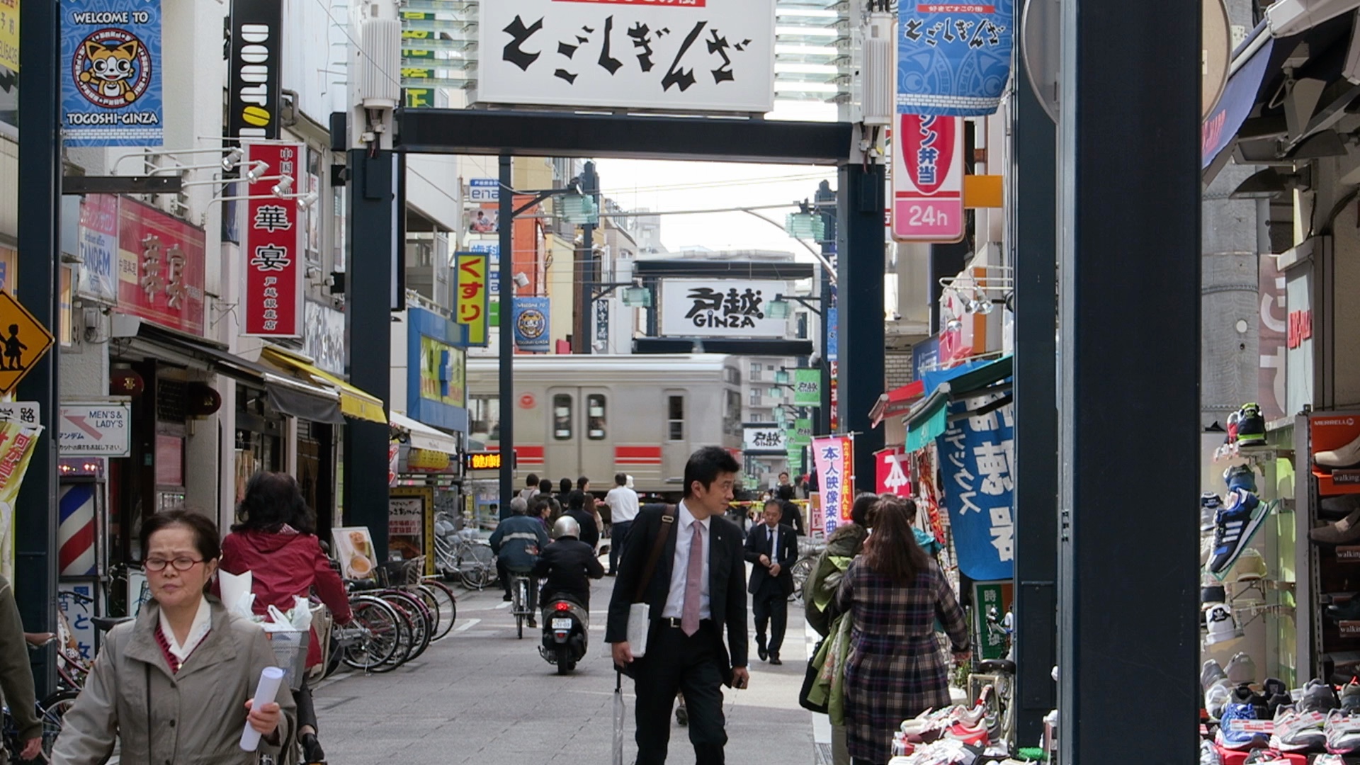 Eine Ein­kaufs­stras­se mit Bahn­über­gang: Die Togo­shi-Gin­za in Tokio.